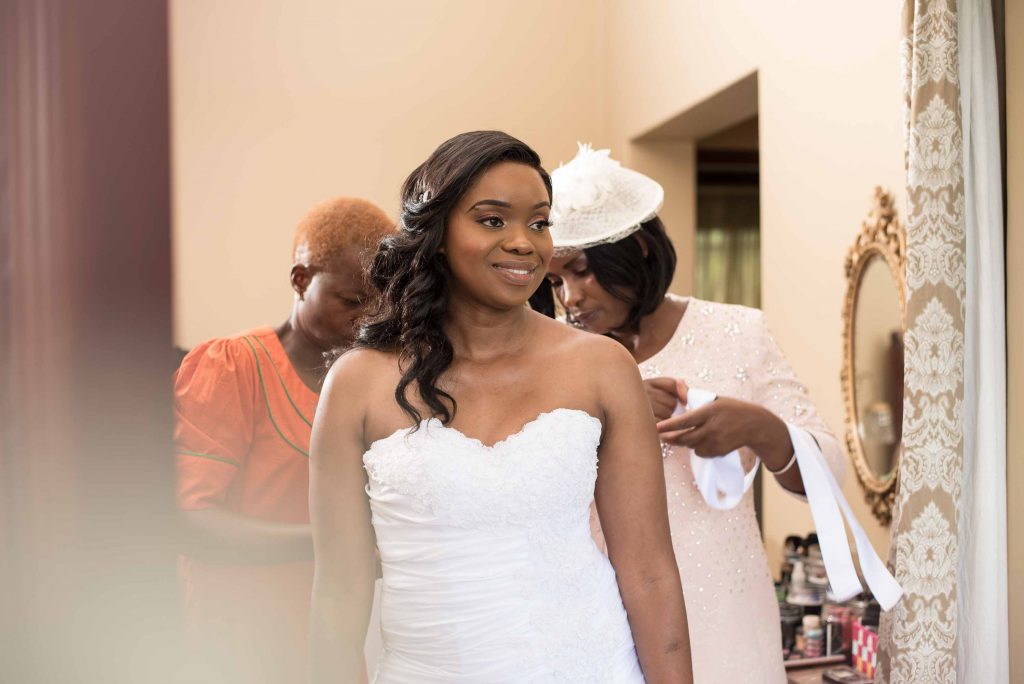 Bride dressing up before her wedding - kundai mendissa dube and ralph kangai wedding - Real Zimbabwe weddings photos - African Weddings on Wedding Expos Africa