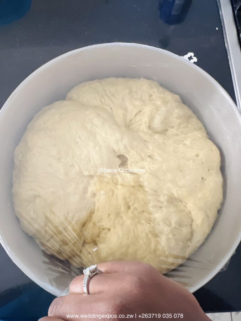Dough for making yeast dinner rolls left to proof in a greased bowl |Zim buns Recipe | Zimbabwe Catering ​